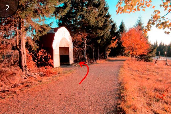 Hinter dieser Hütte links abbiegen und über die Wiese am Waldrand entlang laufen. Sie sehen Reste eines Weges.